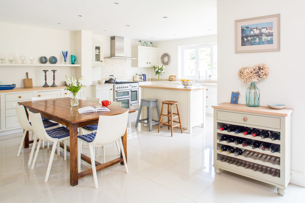 Large traditional l-shaped eat-in kitchen in Buckinghamshire with a farmhouse sink, flat-panel cabinets, white cabinets, solid surface benchtops, grey splashback, ceramic splashback, stainless steel appliances, ceramic floors, with island and white floor.