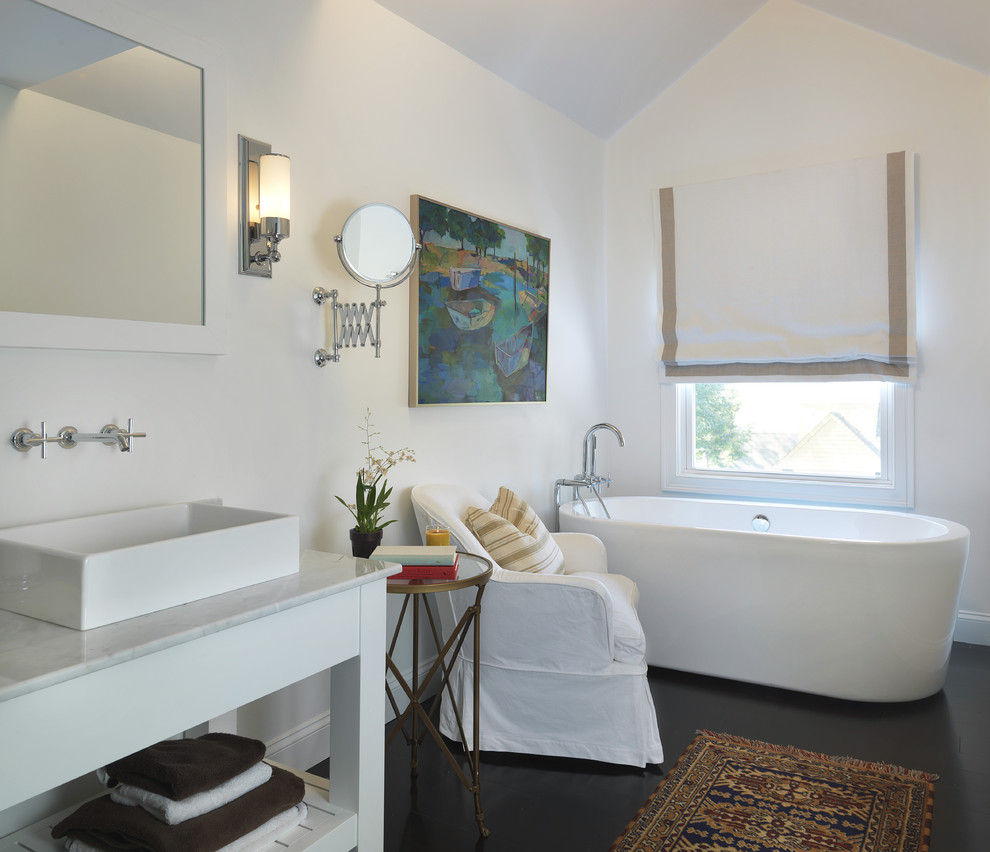 Photo of a beach style bathroom in Providence with a freestanding tub, a vessel sink and black floor.