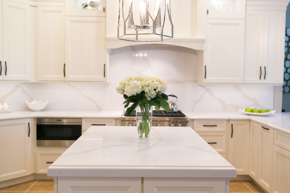 Example of a mid-sized transitional u-shaped open concept kitchen design in Orlando with recessed-panel cabinets, white cabinets, quartzite countertops, white backsplash, stone slab backsplash, stainless steel appliances and a peninsula