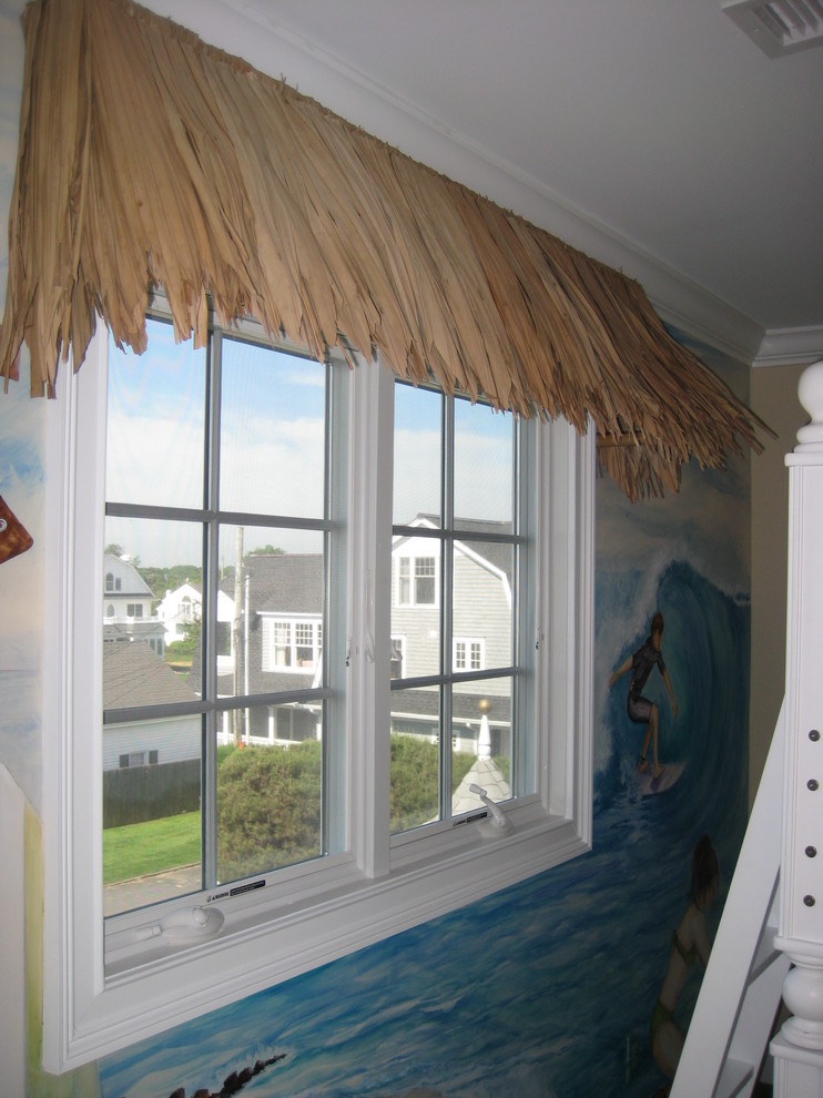Photo of a small beach style gender-neutral kids' bedroom for kids 4-10 years old in New York with multi-coloured walls, carpet and green floor.