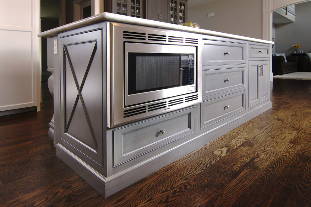 Inspiration for a large transitional u-shaped dark wood floor eat-in kitchen remodel in New York with white cabinets, white backsplash, an island, a farmhouse sink, beaded inset cabinets, subway tile backsplash and paneled appliances