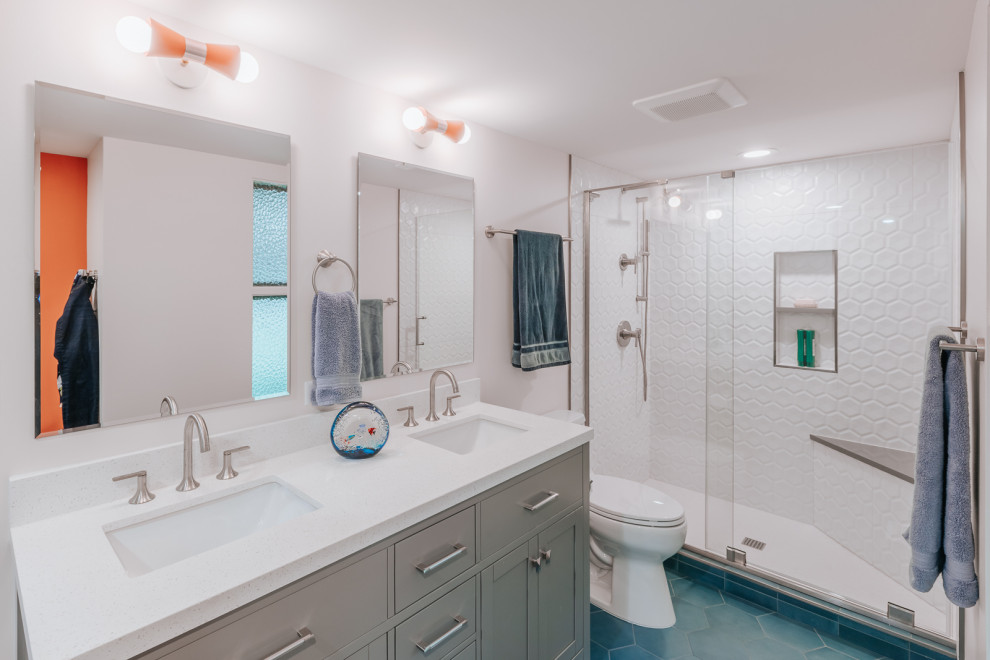 На фото: главная ванная комната среднего размера в стиле модернизм с фасадами с утопленной филенкой, серыми фасадами, душем в нише, белой плиткой, белыми стенами, полом из цементной плитки, врезной раковиной, синим полом, душем с раздвижными дверями, белой столешницей, сиденьем для душа, тумбой под две раковины и встроенной тумбой