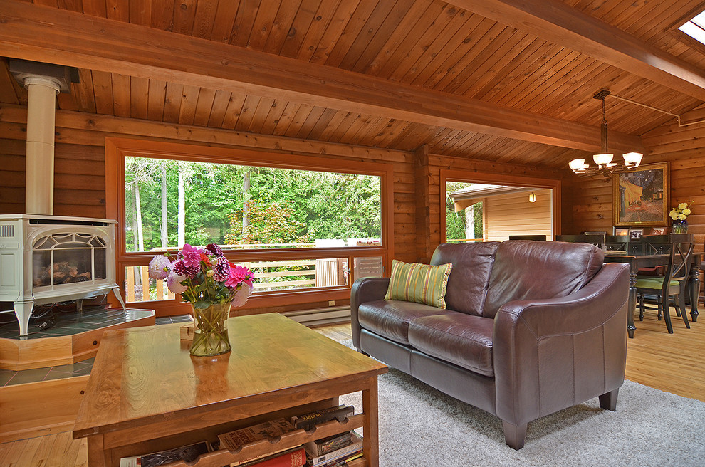 This is an example of a large country open concept living room in Seattle with medium hardwood floors, a wood stove and no tv.