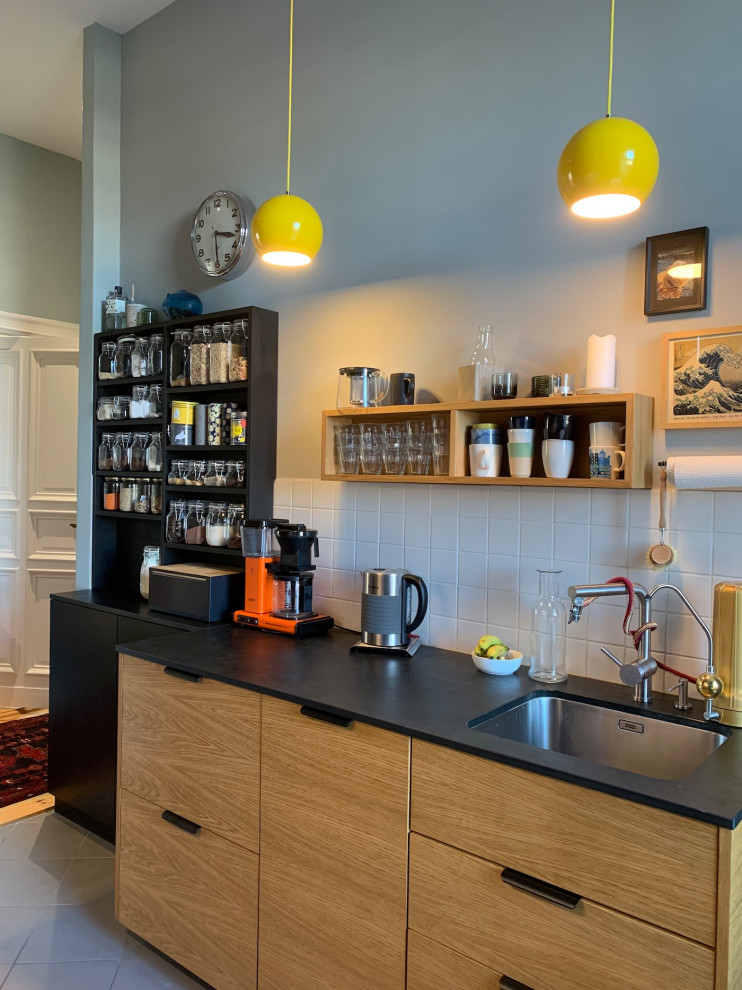 Inspiration for a small contemporary galley separate kitchen in Berlin with medium wood cabinets, limestone benchtops, no island and black benchtop.