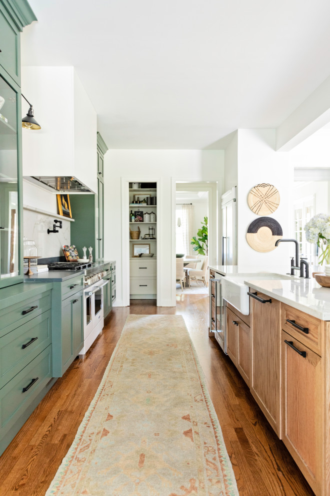 Inspiration for a large transitional galley open plan kitchen in Orlando with a farmhouse sink, shaker cabinets, medium hardwood floors, with island and brown floor.