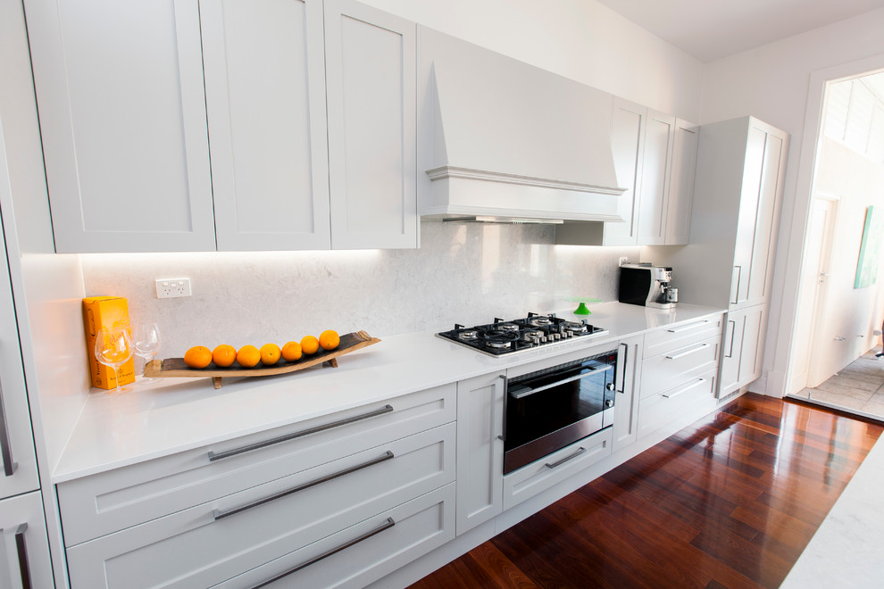 Large contemporary galley eat-in kitchen in Adelaide with an undermount sink, shaker cabinets, grey cabinets, quartz benchtops, grey splashback, stone slab splashback, black appliances, dark hardwood floors and with island.