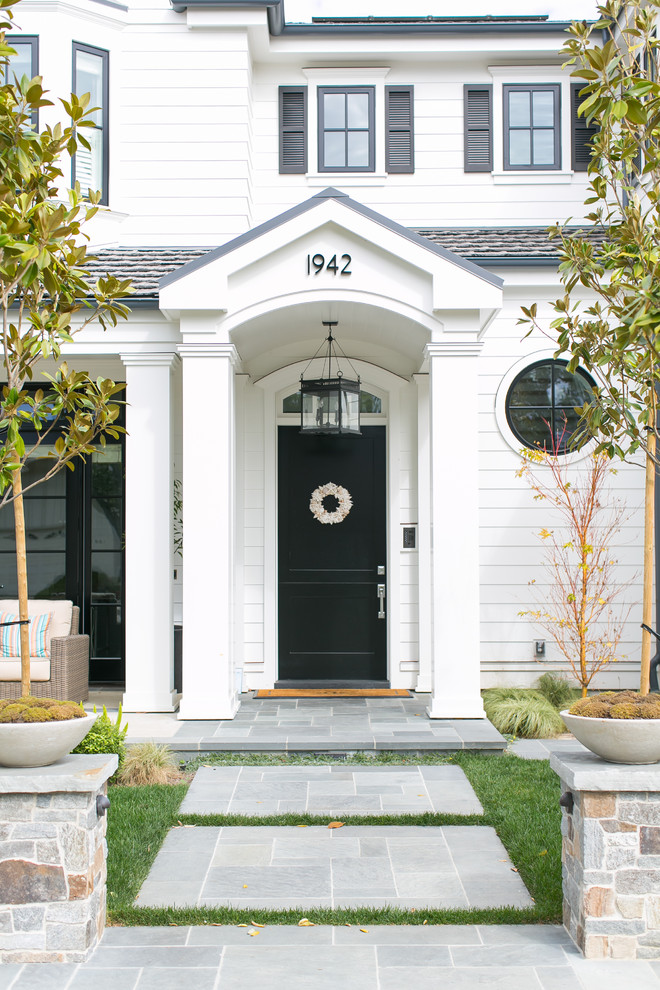 Inspiration for a transitional entryway in Orange County with a single front door and a black front door.