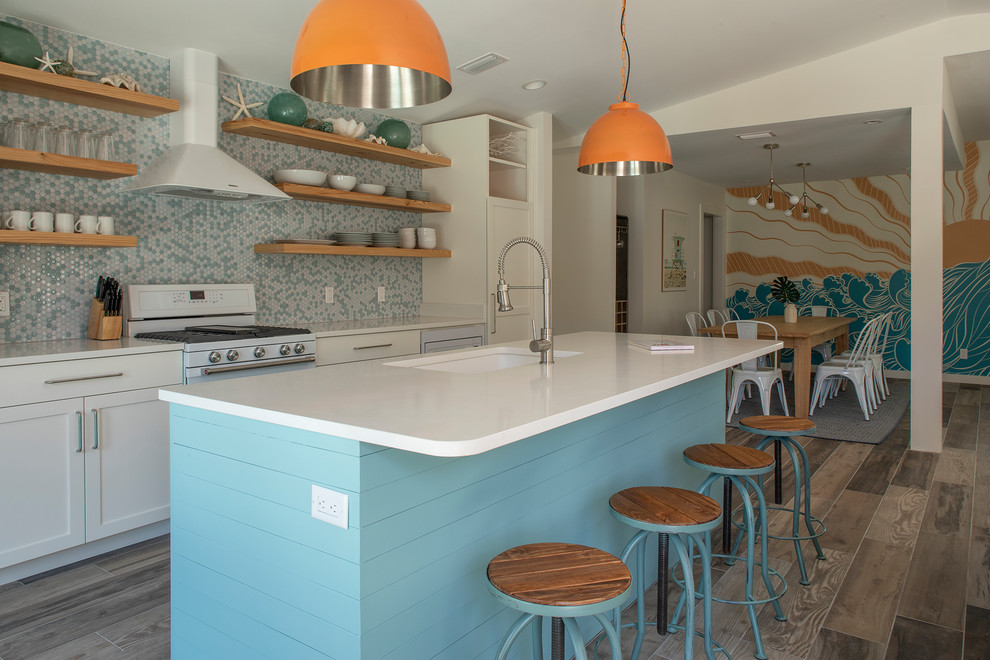 This is an example of a mid-sized midcentury single-wall open plan kitchen in Miami with an undermount sink, recessed-panel cabinets, turquoise cabinets, quartzite benchtops, multi-coloured splashback, ceramic splashback, white appliances, ceramic floors, with island, brown floor and white benchtop.