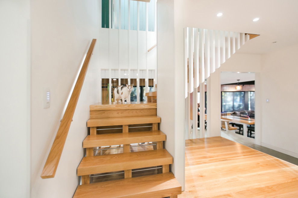 Ejemplo de escalera en L nórdica de tamaño medio sin contrahuella con escalones de madera, barandilla de madera y madera