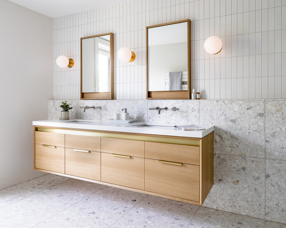 This is an example of a large contemporary master bathroom in Philadelphia with light wood cabinets, white tile, ceramic tile, white walls, terrazzo floors, an undermount sink, engineered quartz benchtops, grey floor, white benchtops, a double vanity, a floating vanity and flat-panel cabinets.