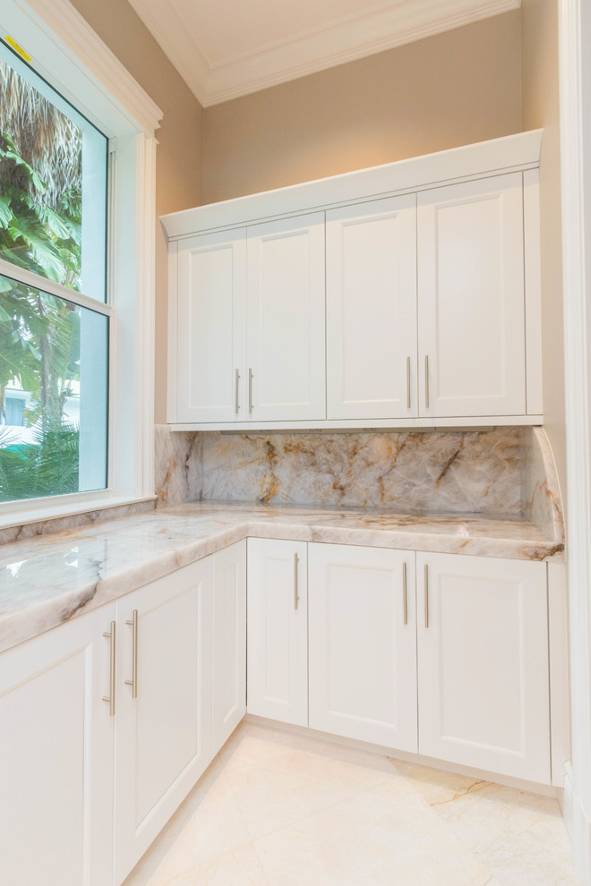 Open concept kitchen - huge transitional u-shaped marble floor and white floor open concept kitchen idea with an undermount sink, flat-panel cabinets, white cabinets, quartzite countertops, white backsplash, stone slab backsplash and two islands