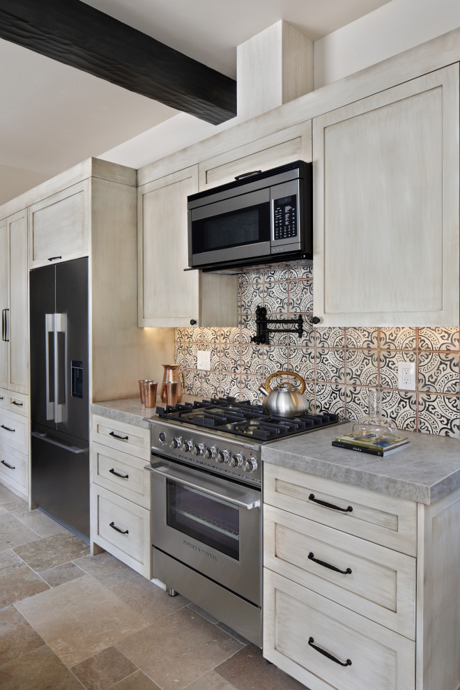 This is an example of a mediterranean single-wall open plan kitchen in San Francisco with recessed-panel cabinets, distressed cabinets, composite countertops, multi-coloured splashback, ceramic splashback, black appliances, ceramic flooring, brown floors, grey worktops and exposed beams.
