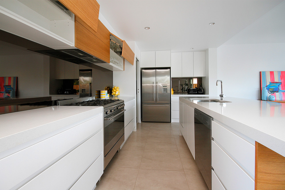 Inspiration for a large beach style open plan kitchen in Sunshine Coast with a double-bowl sink, white cabinets, quartz benchtops, metallic splashback, glass sheet splashback, stainless steel appliances, porcelain floors and with island.