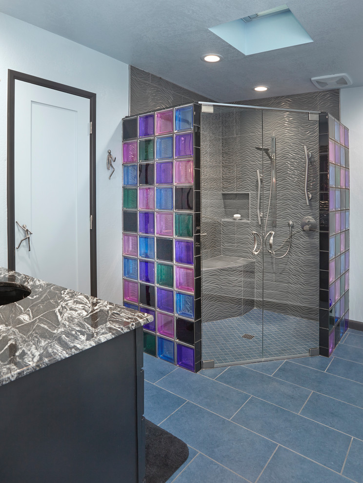 Inspiration for a large eclectic 3/4 bathroom in Phoenix with flat-panel cabinets, dark wood cabinets, a corner shower, blue tile, glass tile, white walls, porcelain floors, an undermount sink, granite benchtops, blue floor, a hinged shower door and black benchtops.