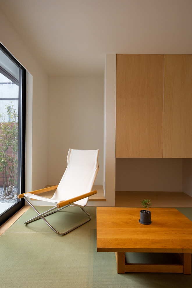На фото: маленькая гостевая спальня (комната для гостей) в стиле модернизм с белыми стенами, татами, зеленым полом, потолком с обоями и обоями на стенах для на участке и в саду