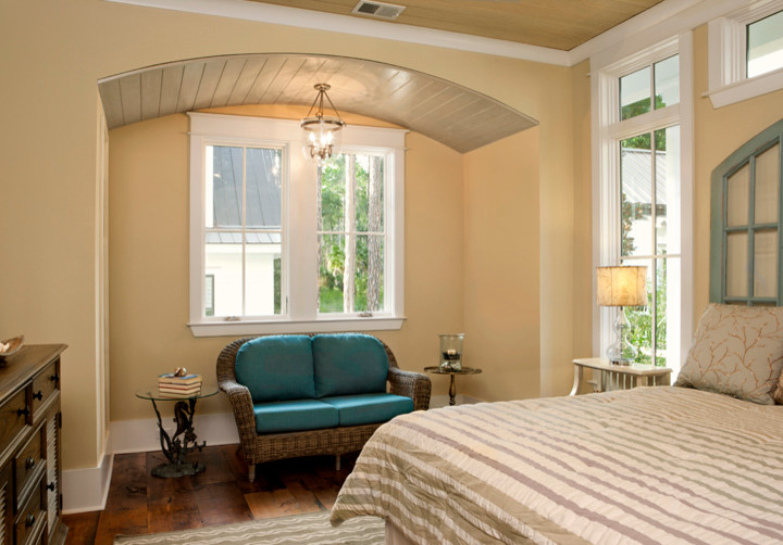 Inspiration for a large beach style master bedroom in Charleston with beige walls and medium hardwood floors.