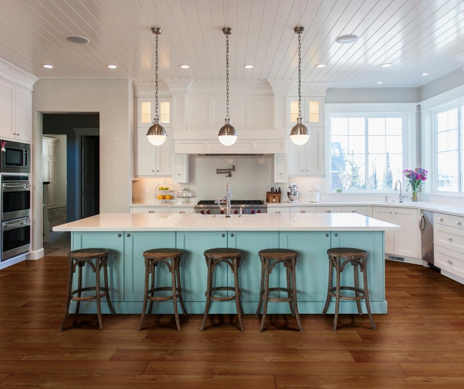 This is an example of a large beach style u-shaped open plan kitchen in San Francisco with an undermount sink, shaker cabinets, white cabinets, quartzite benchtops, white splashback, stainless steel appliances, medium hardwood floors, with island and brown floor.