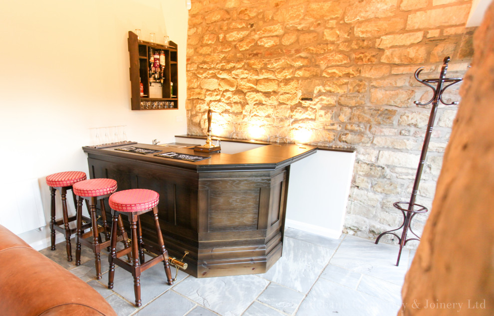 Esempio di un piccolo angolo bar con lavandino classico con lavello da incasso, ante con bugna sagomata, ante in legno bruno, top in legno, pavimento in ardesia, pavimento grigio e top marrone