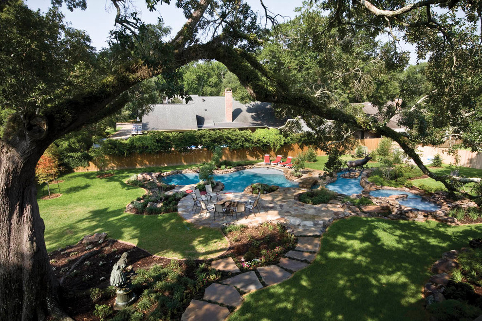 Inspiration for a mid-sized contemporary backyard custom-shaped natural pool in New Orleans with a hot tub and natural stone pavers.