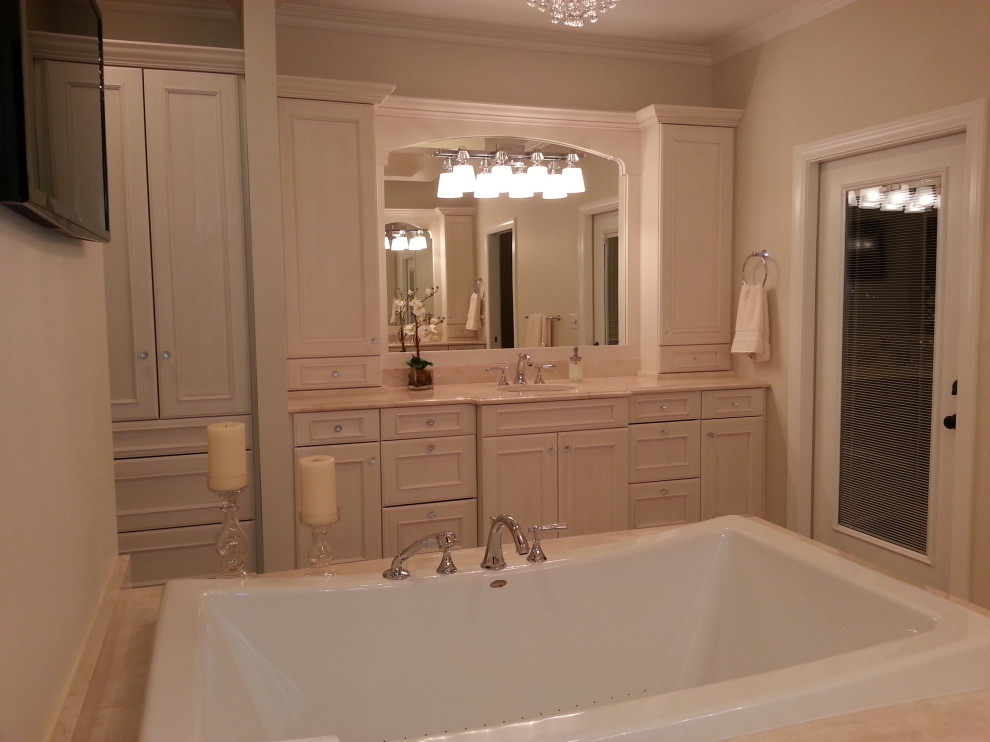 Large traditional master bathroom in St Louis with recessed-panel cabinets, beige cabinets, a drop-in tub, an open shower, a one-piece toilet, beige tile, travertine, beige walls, travertine floors, an undermount sink, granite benchtops, beige floor, an open shower, white benchtops, an enclosed toilet, a double vanity and a built-in vanity.