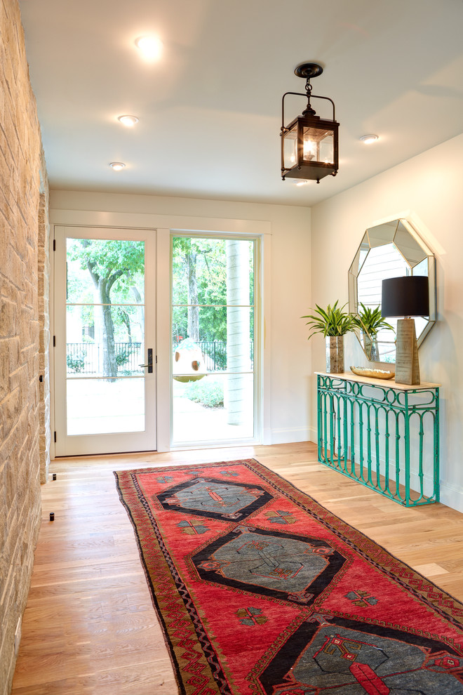 Design ideas for a large transitional foyer in Austin with white walls, light hardwood floors, a single front door and a white front door.