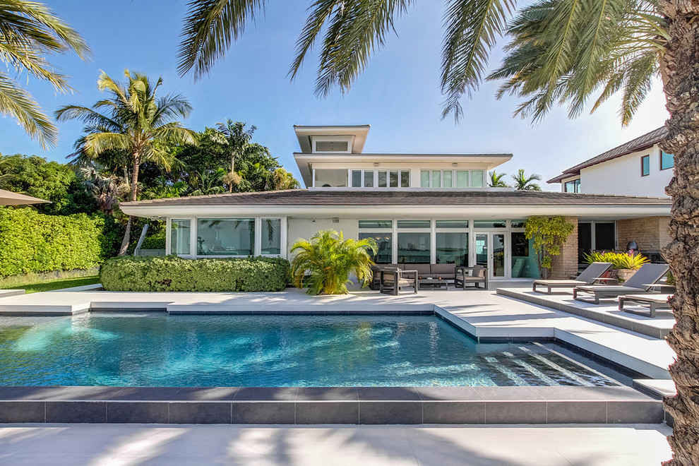 Photo of a contemporary backyard custom-shaped lap pool in Miami.