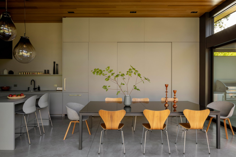 На фото: столовая в стиле модернизм с серыми стенами, бетонным полом, серым полом и деревянным потолком