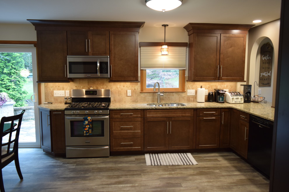 Kitchen - transitional l-shaped kitchen idea with an undermount sink, recessed-panel cabinets, brown cabinets, quartz countertops, beige backsplash, ceramic backsplash, black appliances and a peninsula