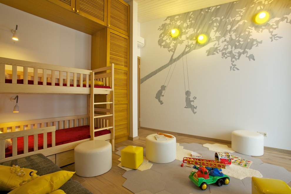 Inspiration for a contemporary gender-neutral kids' bedroom for kids 4-10 years old with white walls and light hardwood floors.