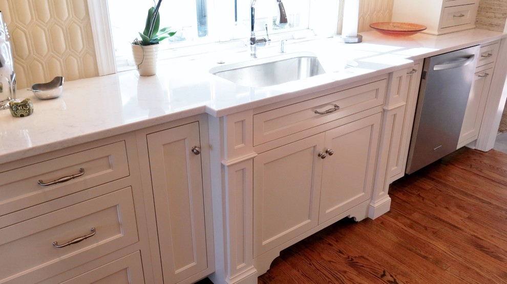 Example of a transitional home design design with white cabinets, quartz countertops and white backsplash