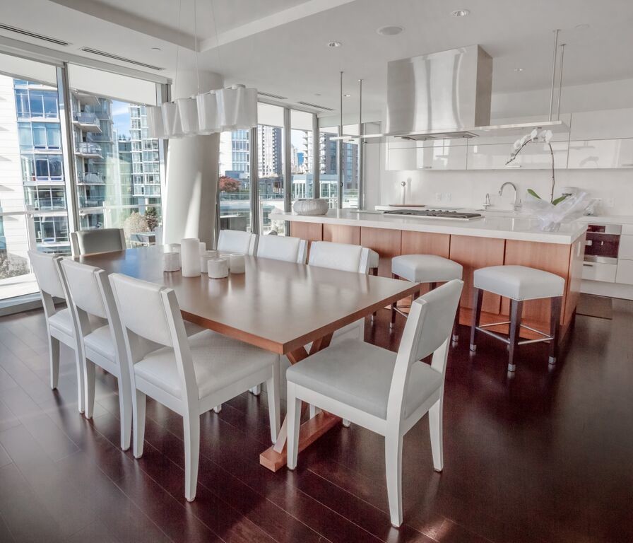 This is an example of a mid-sized transitional kitchen/dining combo in Vancouver with white walls, medium hardwood floors and a wood fireplace surround.