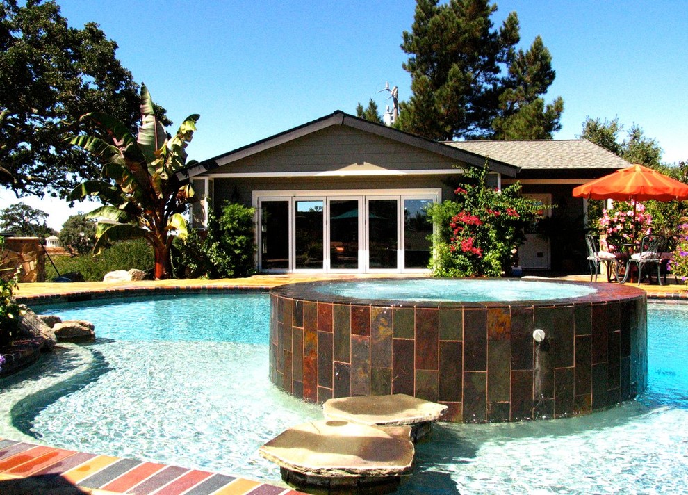 Photo of a mid-sized contemporary backyard custom-shaped lap pool in San Francisco with a hot tub and natural stone pavers.