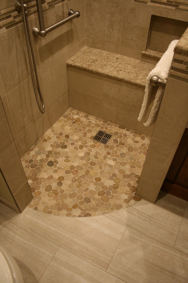 Design ideas for a mid-sized transitional master bathroom in Chicago with flat-panel cabinets, brown cabinets, a drop-in tub, a curbless shower, beige tile, pebble tile and engineered quartz benchtops.