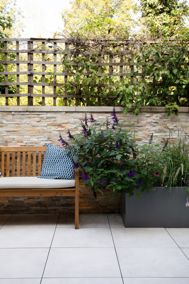 Design ideas for a small modern courtyard deck in London with a vertical garden and no cover.
