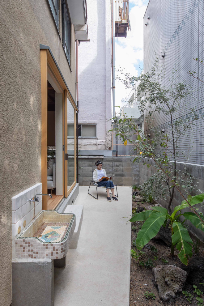 Idée de décoration pour une petite terrasse arrière minimaliste avec des pavés en béton et aucune couverture.