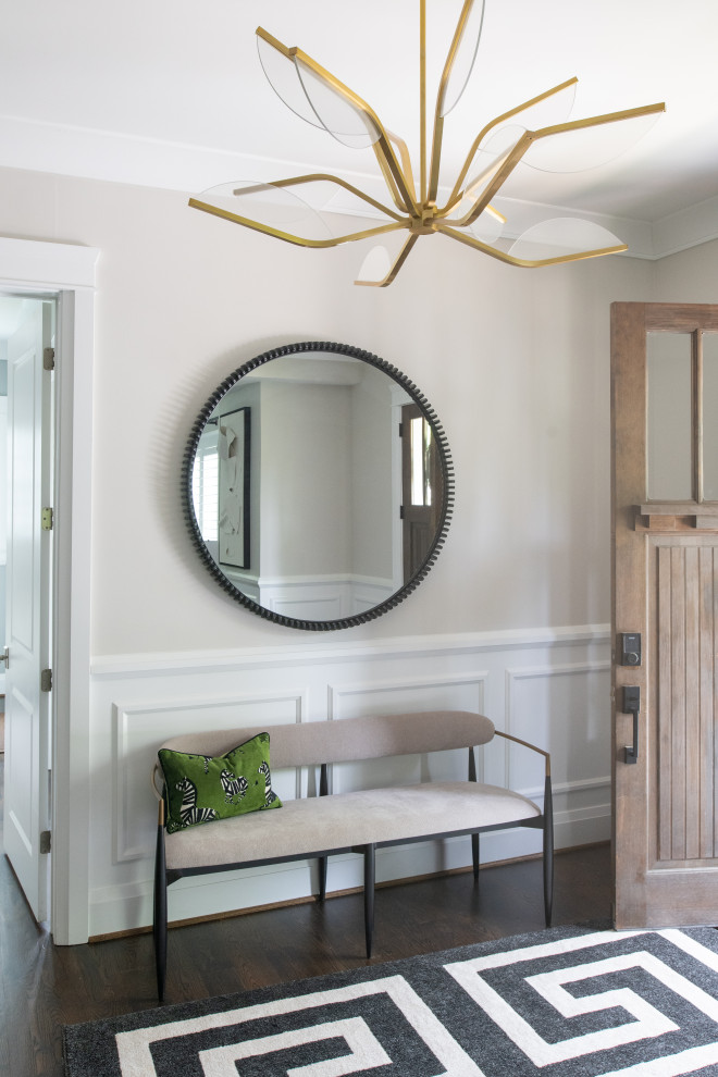 Foyer - large transitional dark wood floor, wainscoting and brown floor foyer idea in DC Metro with a medium wood front door and beige walls