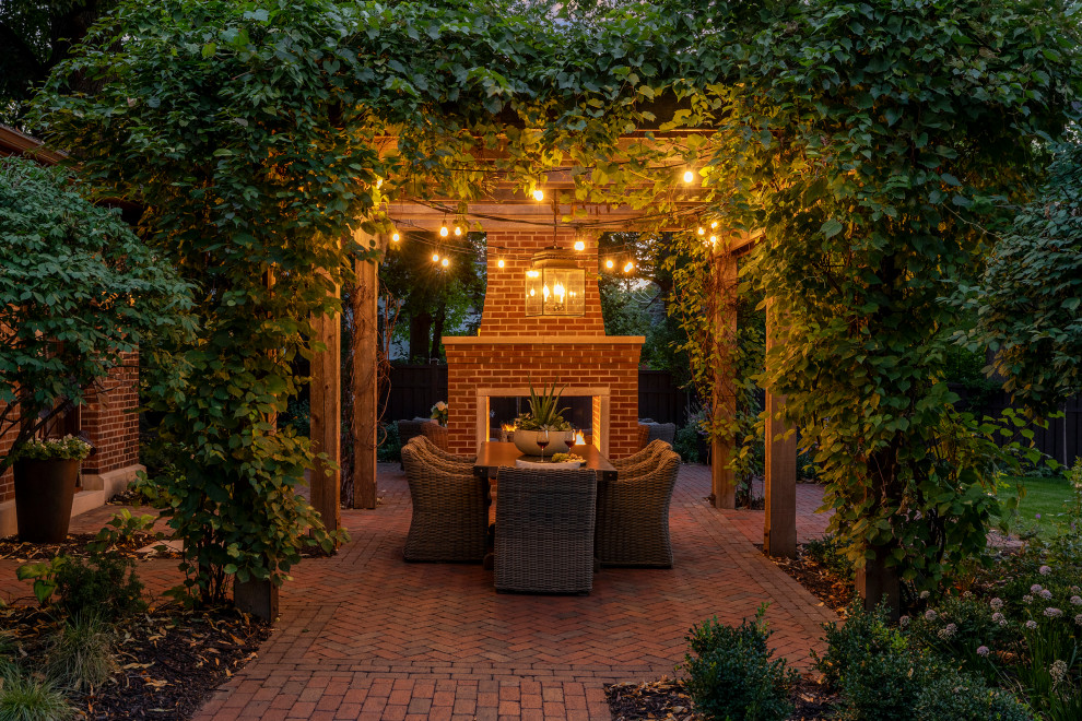 Idee per un piccolo patio o portico stile americano dietro casa con un caminetto, pavimentazioni in mattoni e una pergola