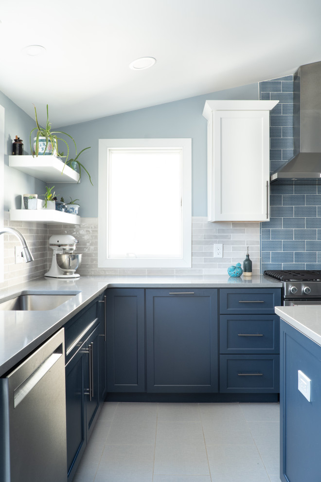 This is an example of a mid-sized eclectic l-shaped eat-in kitchen in Baltimore with an undermount sink, shaker cabinets, white cabinets, quartz benchtops, blue splashback, ceramic splashback, stainless steel appliances, ceramic floors, with island, grey floor and grey benchtop.