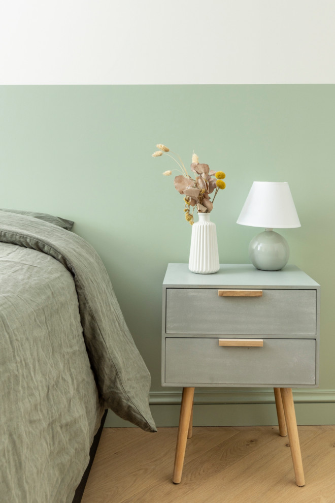 Cette image montre une chambre parentale blanche et bois design de taille moyenne avec un mur vert, parquet clair et dressing.