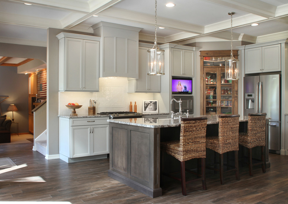 Eat-in kitchen - large transitional l-shaped porcelain tile eat-in kitchen idea with a farmhouse sink, granite countertops, white backsplash, ceramic backsplash, stainless steel appliances and an island