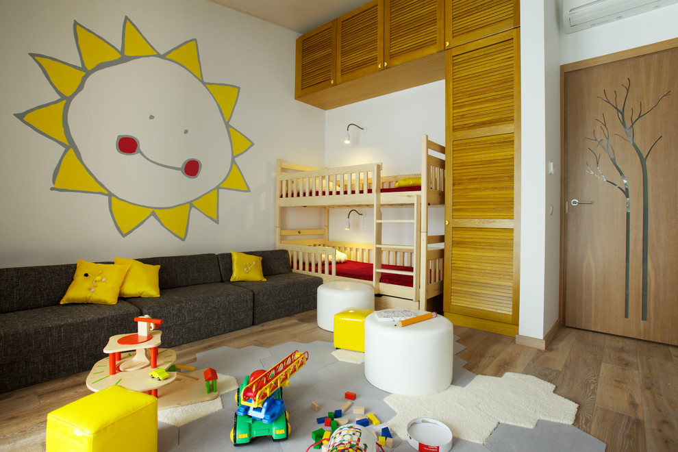 Trendy gender-neutral light wood floor kids' room photo with white walls