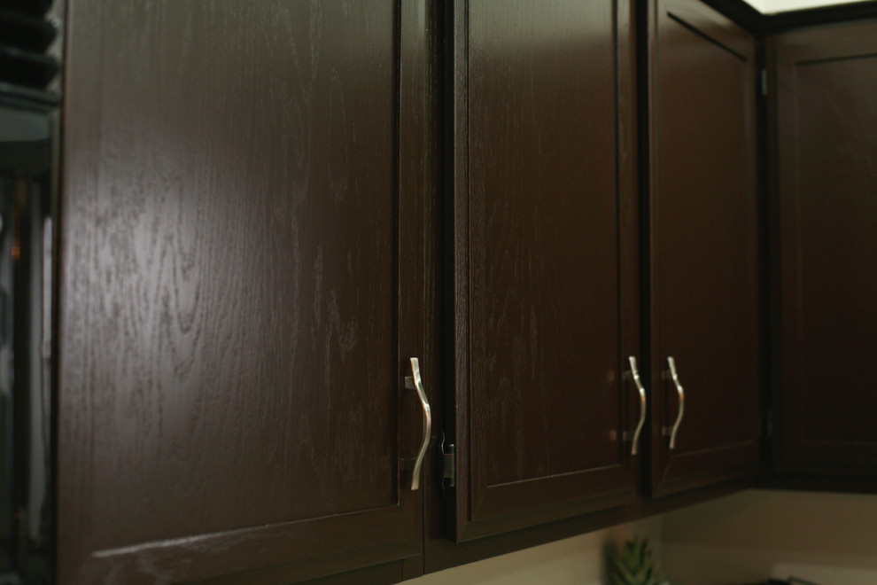 Inspiration for a mid-sized transitional u-shaped ceramic tile enclosed kitchen remodel with dark wood cabinets, granite countertops, stainless steel appliances, a double-bowl sink, recessed-panel cabinets and a peninsula