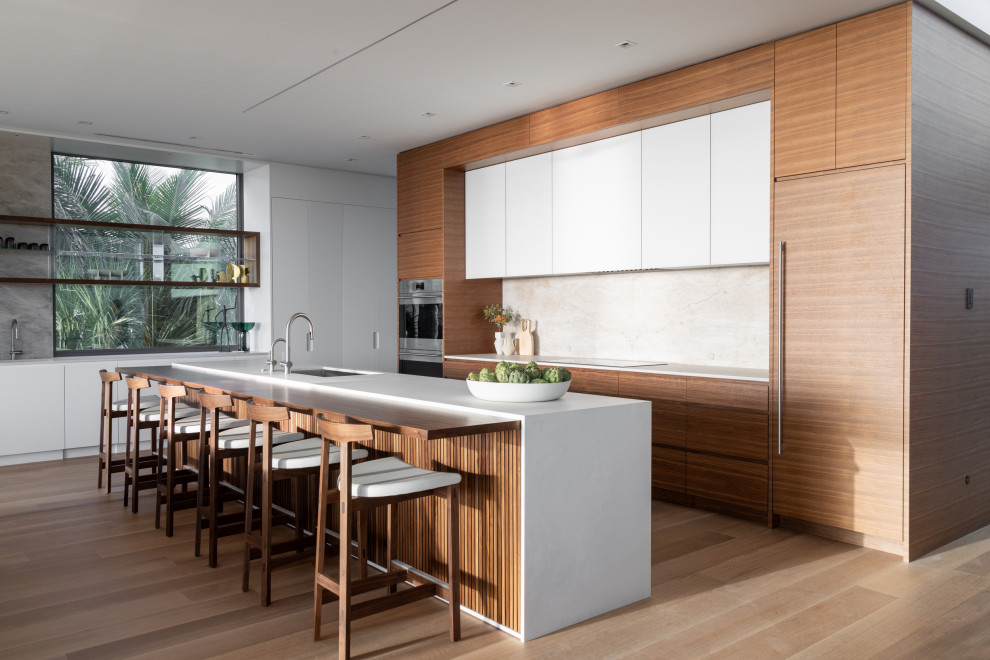 Esempio di una cucina moderna con lavello sottopiano, ante lisce, ante in legno scuro, elettrodomestici in acciaio inossidabile, parquet chiaro, pavimento beige e top bianco