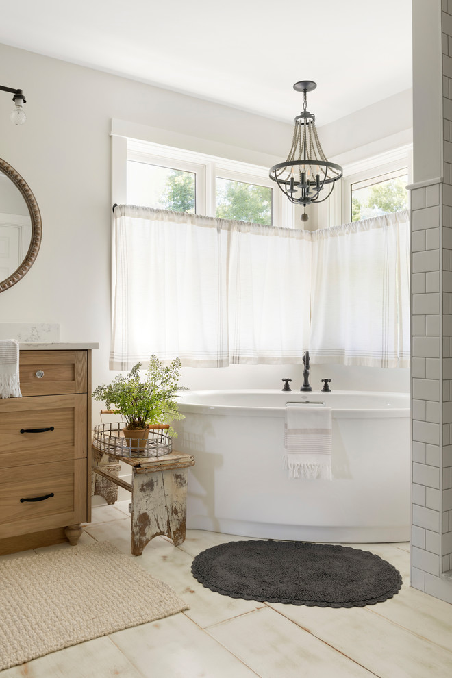 Inspiration for a large modern master bathroom in Minneapolis with beaded inset cabinets, light wood cabinets, a freestanding tub, an open shower, a one-piece toilet, beige walls, painted wood floors, a drop-in sink, white floor, an open shower and white benchtops.