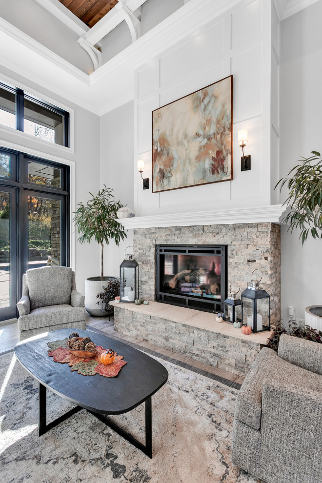 This is an example of an expansive modern formal open concept living room in Other with grey walls, ceramic floors, a standard fireplace, a stone fireplace surround, grey floor, coffered and panelled walls.
