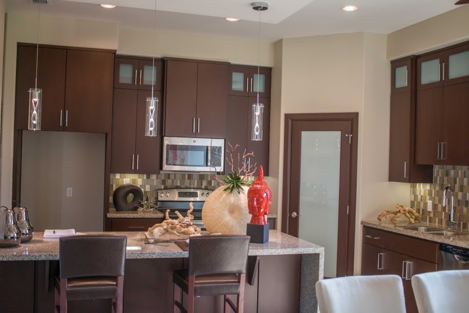 Inspiration for a mid-sized transitional l-shaped eat-in kitchen remodel with a double-bowl sink, flat-panel cabinets, brown cabinets, quartz countertops, multicolored backsplash, glass sheet backsplash, stainless steel appliances and an island