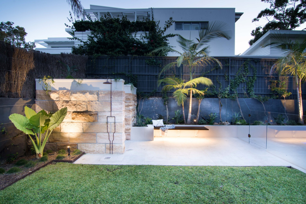 Inspiration for a large contemporary back full sun garden for summer in Sydney with a fire feature, concrete paving and a stone fence.