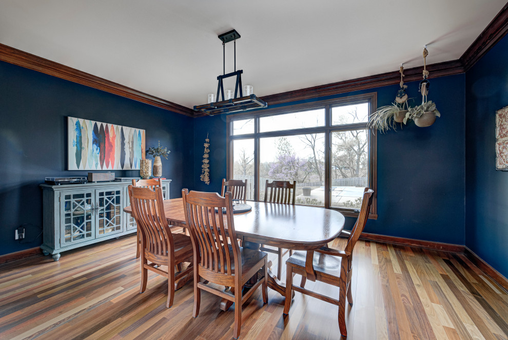 Aménagement d'une salle à manger contemporaine fermée et de taille moyenne avec un mur bleu, un sol en bois brun et aucune cheminée.
