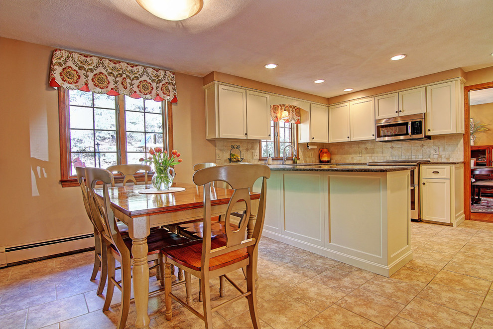 Example of a mid-sized transitional u-shaped porcelain tile enclosed kitchen design in Providence with raised-panel cabinets, white cabinets, granite countertops, porcelain backsplash, stainless steel appliances, an undermount sink, beige backsplash and a peninsula