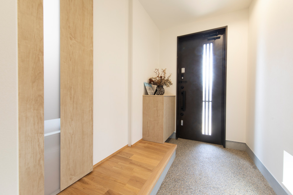 Esempio di un corridoio con pareti bianche, pavimento in cemento, una porta singola, una porta in legno bruno, pavimento grigio, soffitto in carta da parati e carta da parati
